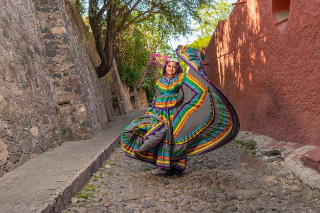 Joven mexicana con un vestido folclórico tradicional de bailarina tradicional de muchos colores