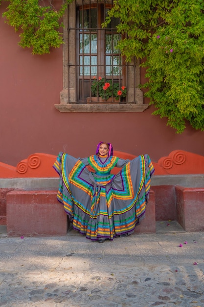 Joven mexicana con un vestido folclórico tradicional de bailarina tradicional de muchos colores