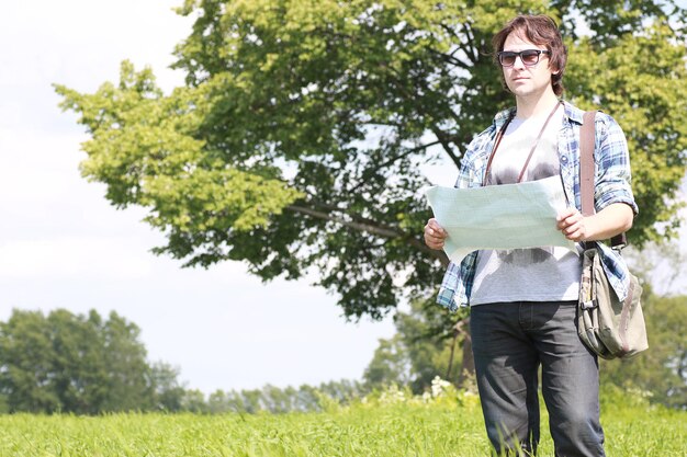 Un joven mira un mapa en la naturaleza para no perderse