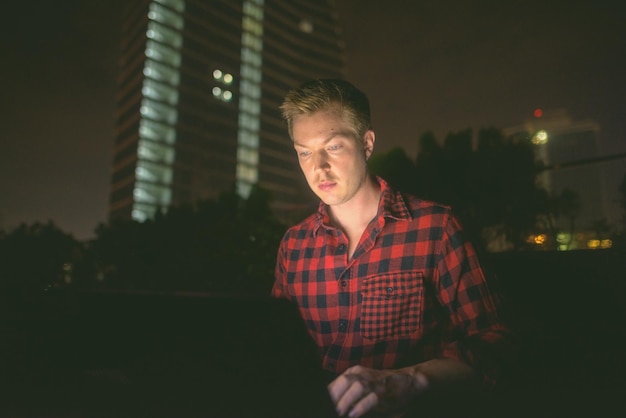 Foto joven mirando a la cámara por la noche