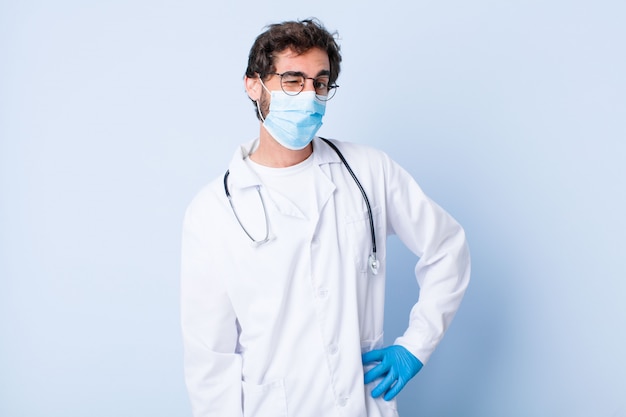 Joven mirando feliz y amable, sonriendo y guiñando un ojo hacia ti con una actitud positiva. concepto de coronavirus