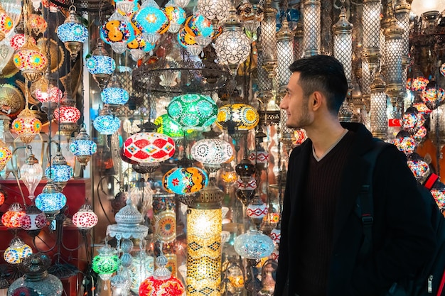 Joven mirando lámparas turcas para la venta en el Gran Bazar de Estambul Turquia