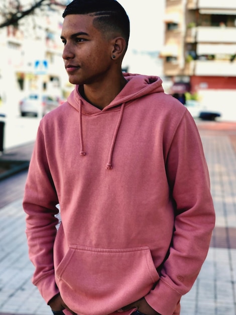 Joven mirando hacia otro lado mientras está de pie en la ciudad