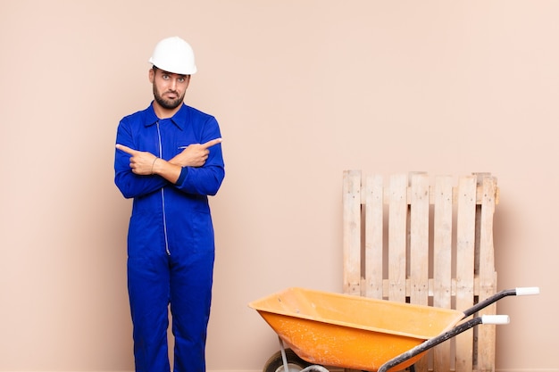 Joven mirando perplejo y confundido, inseguro y apuntando en direcciones opuestas con dudas concepto de construcción