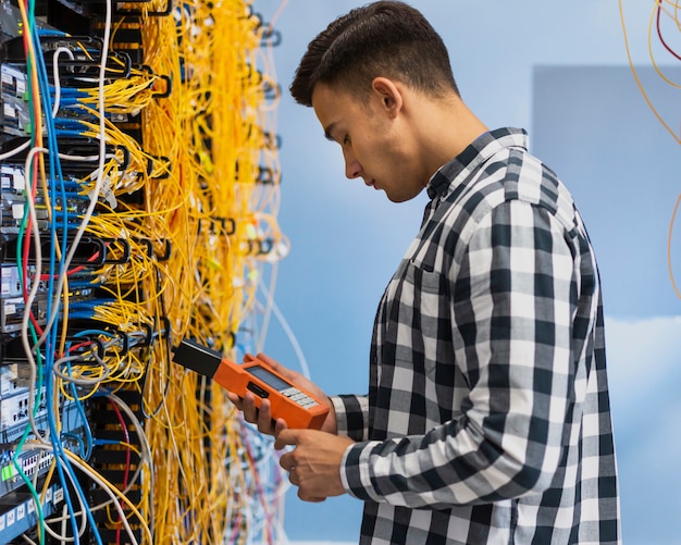 Foto joven mirando probador de fibra óptica