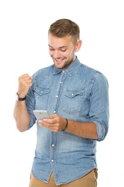 Joven mirando en su teléfono inteligente. expresión feliz