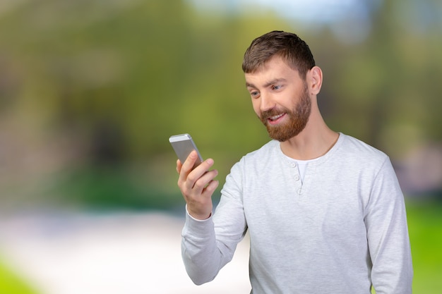 Joven mirando su teléfono inteligente