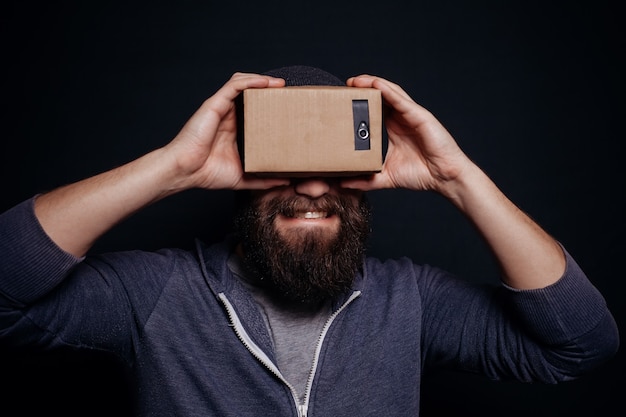 Joven mirando a través de auriculares VR de cartón