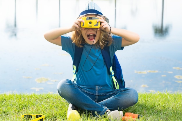 Joven mirando a través de binoculares Niño Scout con sombrero de explorador y mochila al aire libre Explorador y aventura con binoculares