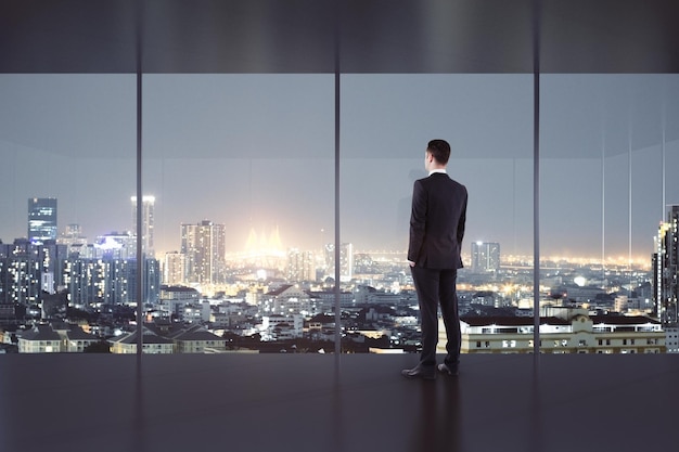 Joven mirando por la ventana en el interior de la oficina moderna con vistas nocturnas a la ciudad 3D Rendering