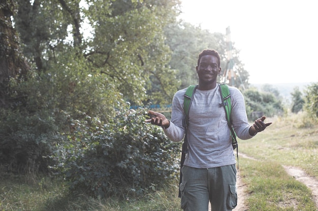 El joven con una mochila está caminando en el bosque.