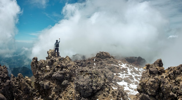 Joven con mochila de pie en la cima de la montaña en el volcán iztaccihuatl