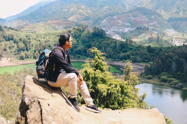 El joven mochilero asiático es feliz y disfruta viajando en la montaña