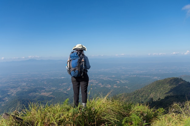 Joven mochilero senderismo en el pico de la montaña, el tema es borrosa. enfoque seleccionado