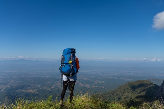 Joven mochilero senderismo en el pico de la montaña, el tema es borrosa. enfoque seleccionado