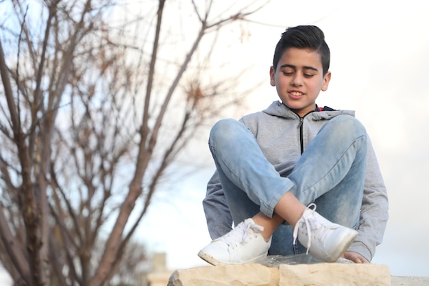 Joven de moda con una camiseta con capucha en el parque al aire libre