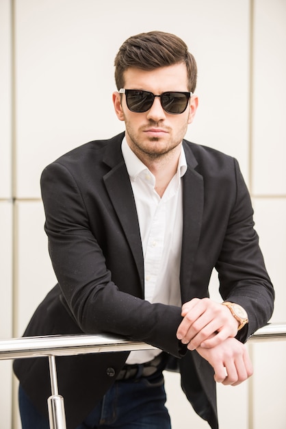 Joven de moda con gafas negras está posando.