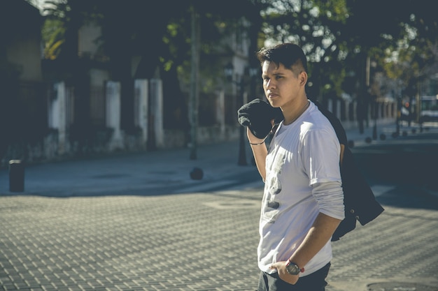 Joven modelado en las calles de una ciudad al atardecer