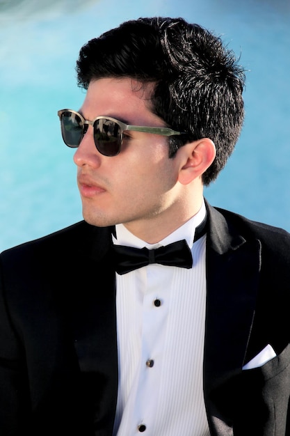 joven modelo masculino con gafas negras y esmoquin
