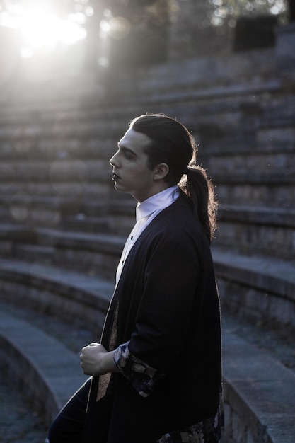 Foto joven modelo masculino de pie en las escaleras durante la puesta de sol