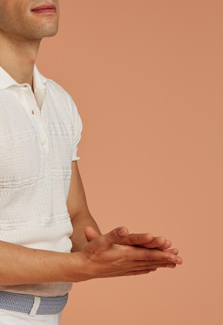 Foto joven modelo masculino con ropa informal bailando lentamente frente a un fondo marrón