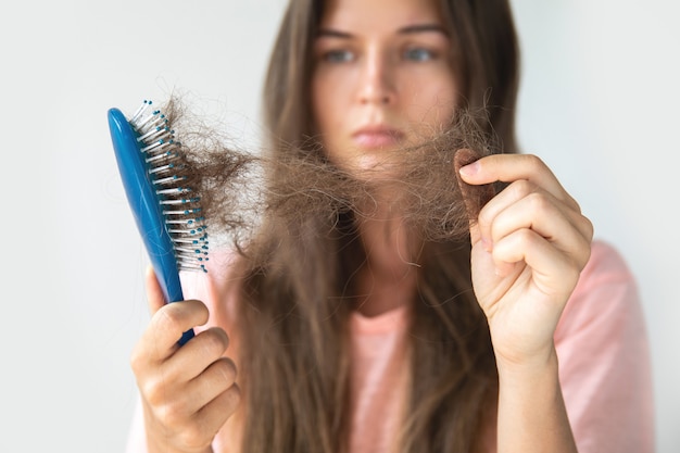 Foto la joven está molesta por la caída del cabello.