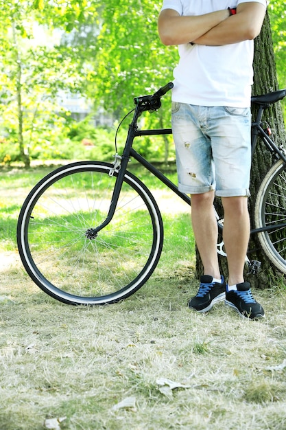 Joven montando en bicicleta en el parque de la ciudad