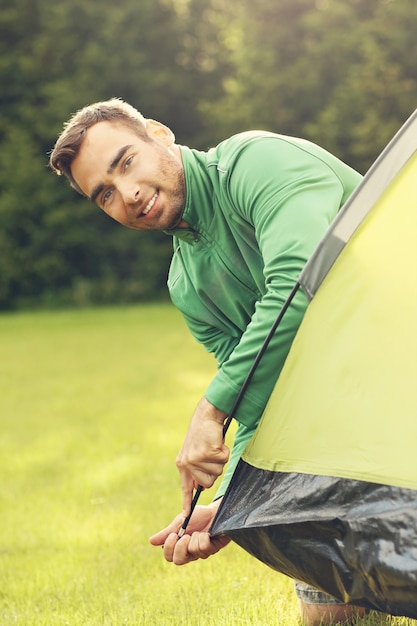 joven montando carpa en el bosque