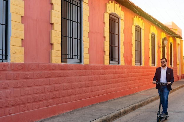 Joven montando e-scooter en la ciudad