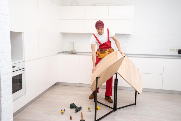 Joven montando muebles de cocina.