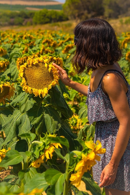 Una joven morena caucásica disfrutando de unos hermosos girasoles