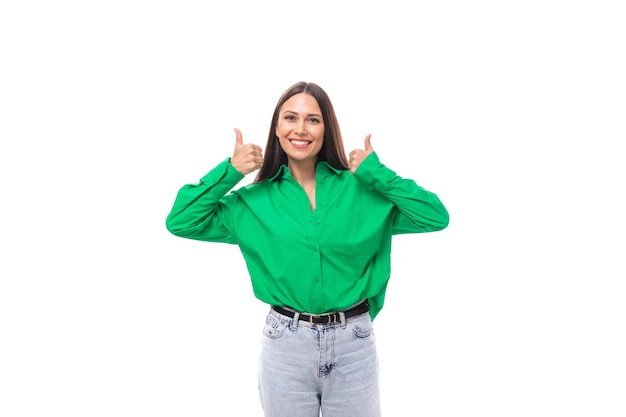 Foto una joven morena caucásica sonriente y alegre con maquillaje vestida con una camisa verde y jeans en un