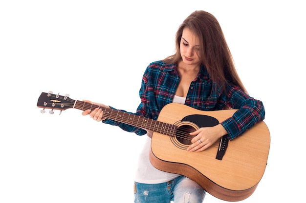 Joven morena encantadora con guitarra en manos aislado sobre fondo blanco.