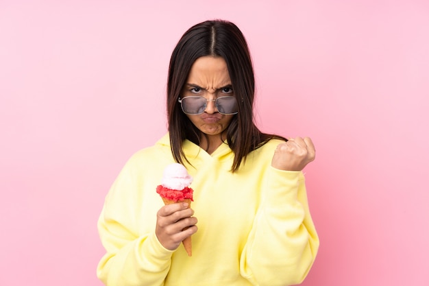 Joven morena con un helado de cucurucho con gesto enojado