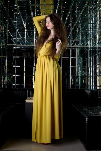 Foto joven morena con un largo vestido amarillo