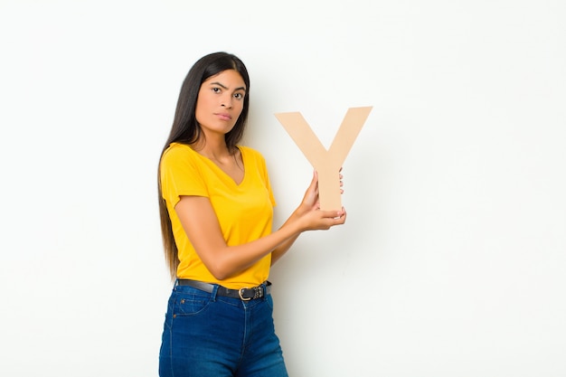 Foto joven morena con la letra y del alfabeto para formar una palabra o una oración