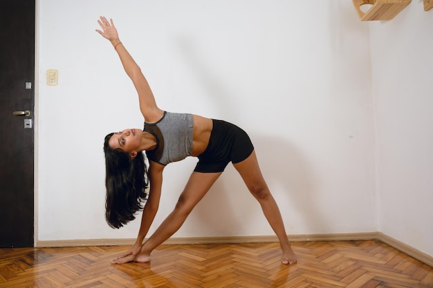 joven morena mujer latina en casa practicando yoga poses espacio de copia