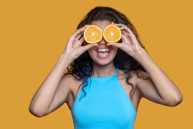 Foto joven morena con naranja en manos