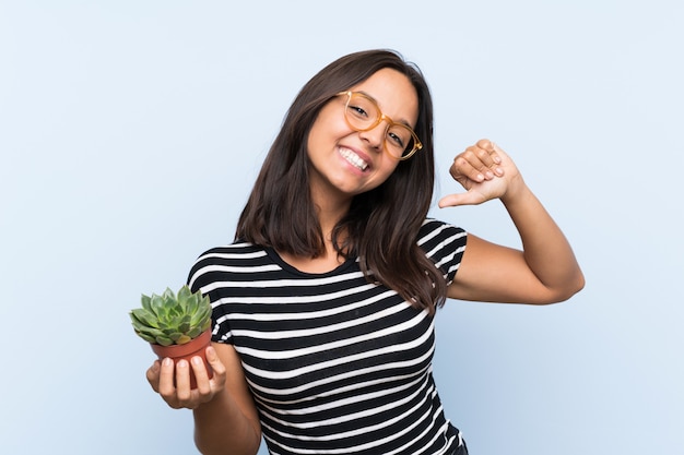 Joven morena con una planta orgullosa y satisfecha