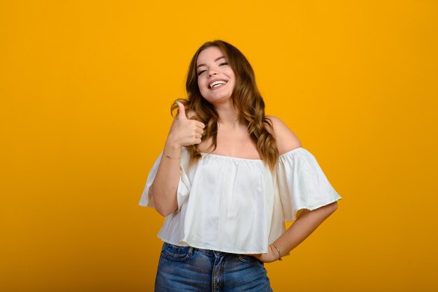 Joven morena con una sonrisa y grandes ojos sorprendidos posando.