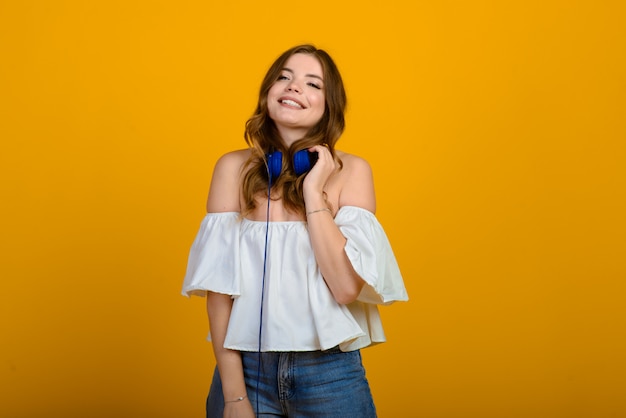 Joven morena con una sonrisa sobre fondo amarillo