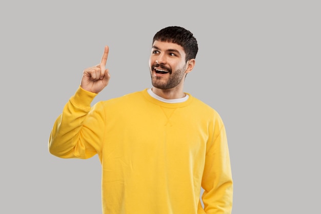 joven mostrando un dedo en una sudadera amarilla