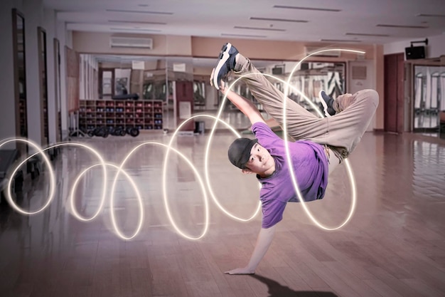 Joven mostrando movimiento de break dance con luces