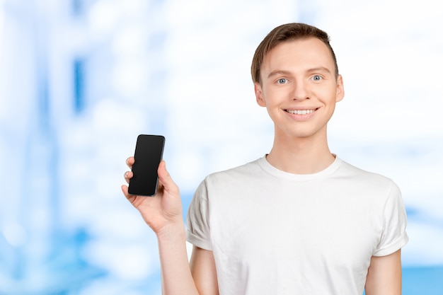 Joven mostrando una pantalla de teléfono en blanco