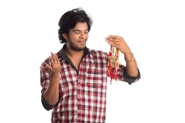 Joven mostrando rakhi en la mano y dando expresión en ocasión del festival Raksha Bandhan.