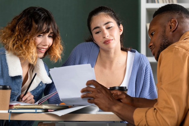 Joven mostrando a sus amigos sus notas durante la sesión de estudio