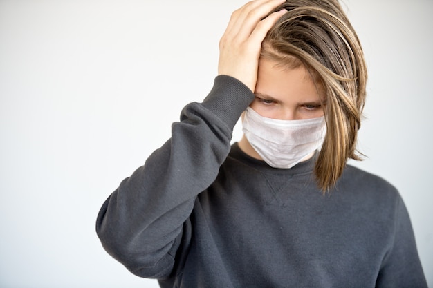 Foto joven muchacho caucásico con máscara protectora contra el coronavirus. hombre con máscara quirúrgica para prevenir el virus.