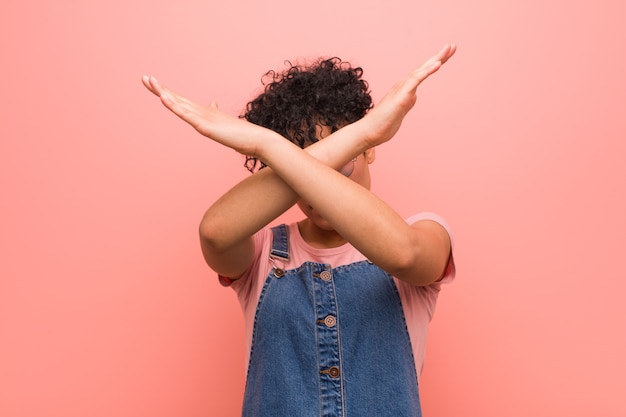 Joven mujer adolescente afroamericana mixta manteniendo dos brazos cruzados