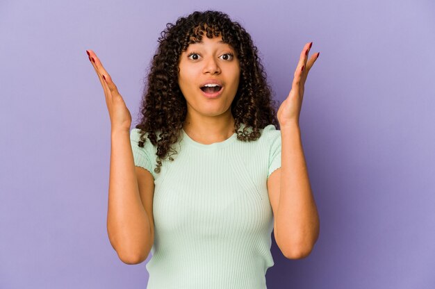 Joven mujer afro aislada celebrando una victoria o un éxito, se sorprende y se sorprende