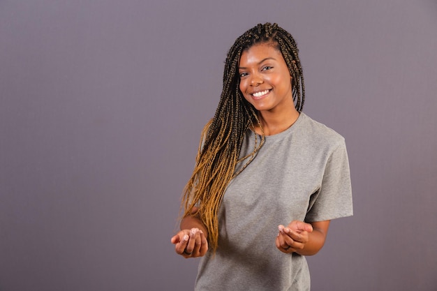 Joven mujer afro brasileña haciendo señas con sus manos ven ven aquí bienvenida